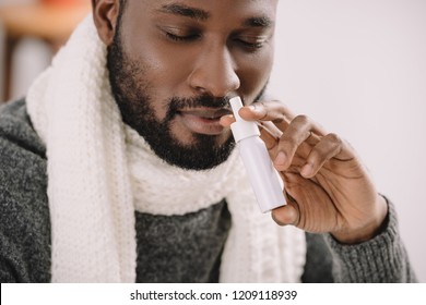 Ill African American Man In Warm Scarf With Nose Spray