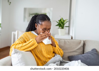 Ill African Young Woman Covered With Blanket Blowing Running Nose Got Fever Caught Cold Sneezing In Tissue Sit On Sofa, Sick Allergic Black Girl Having Allergy Symptoms Coughing At Home, Flu Concept