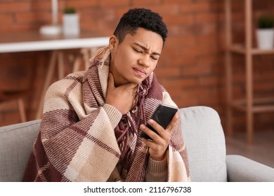 Ill African-American Guy With Mobile Phone At Home