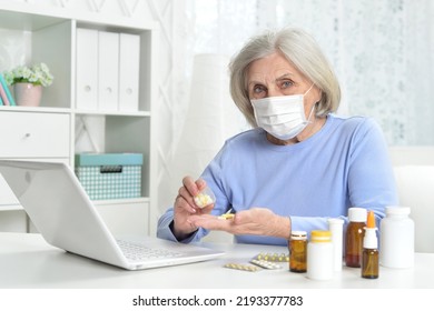 Ill Beautiful Senior Woman  With Facial Mask Holding Pills