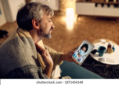 Ill Man Complaining About Sore Throat While Having Video Call With A Doctor At Night During Coronavirus Pandemic.  