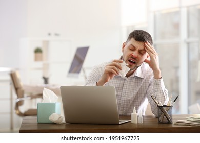 Ill Man At Table With Nasal Spray, Drops And Box Of Paper Tissues In Office