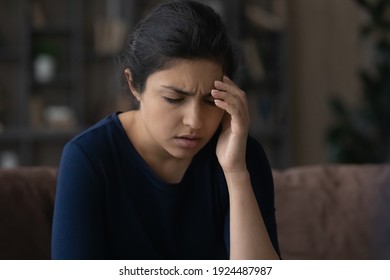 Ill Millennial Indian Woman Suffer From Migraine Or Headache At Home. Unhealthy Sick Young Mixed Race Female Struggle With Dizziness Or Blurry Vision, Infected With Covid-19. Health Problem Concept.