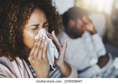 Ill or sick woman with allergy, sinus infection sneezing in tissue or blowing nose during flu season at home. Sick girl caught a bad cold showing symptoms of covid, or suffering from a virus disease - Shutterstock ID 2190358047