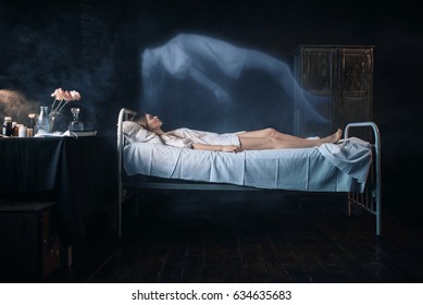 Ill woman lying in hospital bed, soul leaves body - Shutterstock ID 634635683