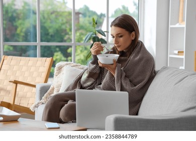 Ill young woman eating chicken soup at home