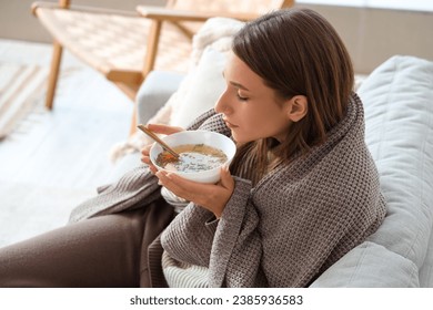 Ill young woman eating chicken soup at home, closeup - Powered by Shutterstock