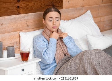 Ill Young Woman With Sore Throat In Bed