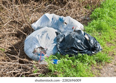 Illegal dumping with plastic bags abandoned in nature - Shutterstock ID 2282696009
