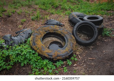 Illegal dumping of tyres in the countryside. The concept of environmental pollution. - Shutterstock ID 2160359757