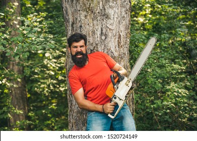 Illegal logging continues today. Lumberjack in the woods with chainsaw axe. Lumberjack on serious face carries chainsaw. Woodcutter with chainsaw on sawmill - Powered by Shutterstock