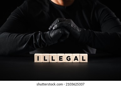 Illegal and unlawful concept. The word illegal on wooden blocks with a criminal person background.