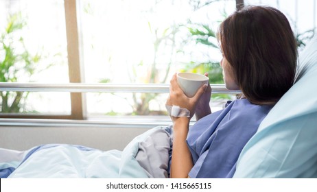 illness asia patient women and hospital concept - illness asian patient women on bed seeing windows in patient room alone of hospital and copy space