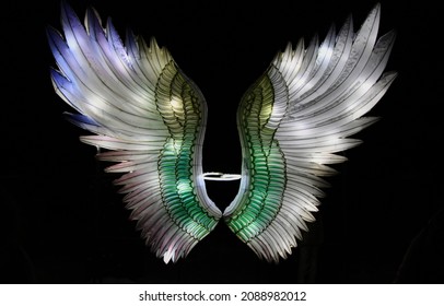 Illuminated angel wings on a black background. Selective focus. High quality photo