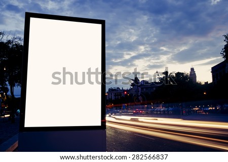 Illuminated blank billboard with copy space for your text message or content, public information board in night city with beautiful dusk on background, advertising mock up banner in metropolitan city