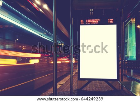 Illuminated blank billboard with copy space for your text message or content, advertising mock up banner of bus station, public information board with blurred vehicles in high speed in night city