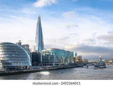 Illuminated buildings of the London United Kingdom city skyline along the Thames River. Photo taken during the afternoon hour in London United Kingdom - Powered by Shutterstock