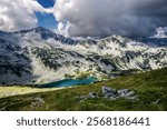 Illuminated by sun Banderishko Dalgoto lake at the foot of the Mt. Banderishki Chukar, view from Todorina Porta pass. Pirin mountains in Bulgaria.