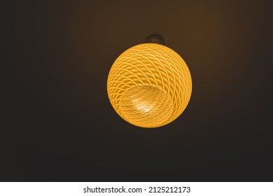 An Illuminated Ceiling Light With A Patterned Glass Lamp Shade