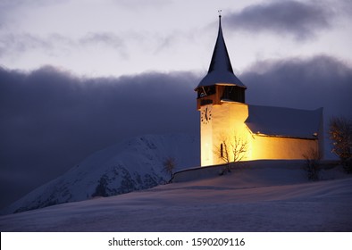 Illuminated Church of the dear Lady in winter, Frauenkirch, near Davos, Grisons, Switzerland Arkivfotografi