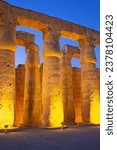 Illuminated columns of Karnak temple. Night photo. Luxor, Egypt. Vertically. 