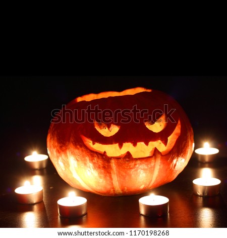 Image, Stock Photo Creepy carved Halloween pumpkin next to burning candle