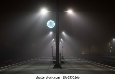 Illuminated, empty platform at a railroad station during a foggy night in autumn. - Powered by Shutterstock