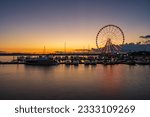 Illuminated ferris wheel at National Harbor near the nation capital of Washington DC at sunset with marina in the foreground