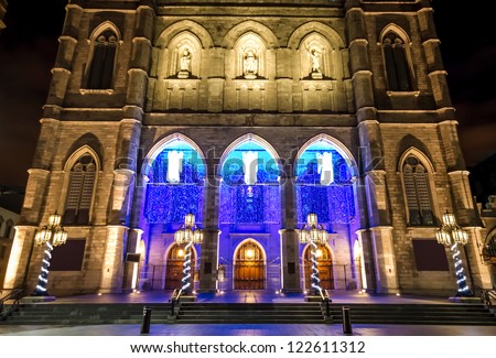 Illuminated Front of the Notre-Dame Basilica in Montreal, with Christmas decorations, at night. (With a little digital noise in the sky)