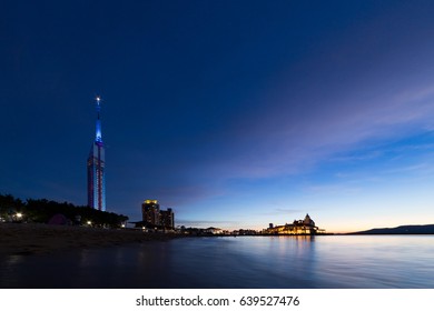 Illuminated Fukuoka tower and ocean in twilight
