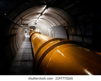 Illuminated gas or oil, orange pipeline in dark tunnel. - Shutterstock ID 2197773265