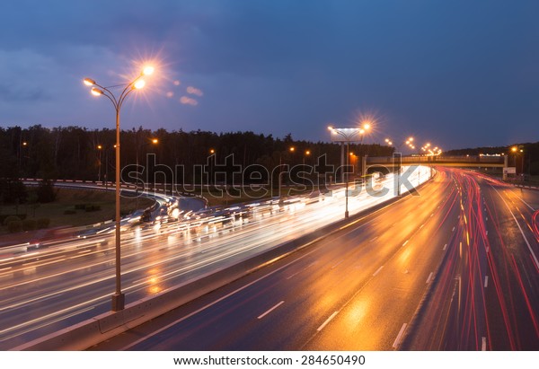 Illuminated highway
at evening with light
trails