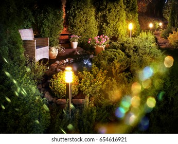 Illuminated Home Garden Patio Plants And Evening Party Lights Near Small Fountain