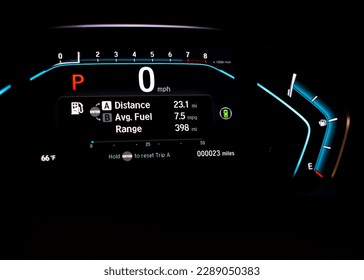 Illuminated instrument panel dashboard on new car with very low milage at only 23 miles odometer, digital display of gauges and indicators, fuel level, engine temperature. Modern driving technology - Powered by Shutterstock - Get 15% off with code: PIKWIZARD15