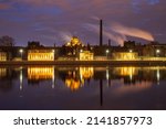 Illuminated Kresty Prison at dawn reflected in the calm water of the Neva River, St. Petersburg, Russia