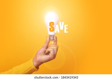 illuminated light bulb with inscripton save over yellow background
