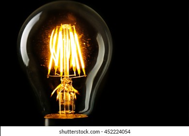 Illuminated light bulb on black background - Powered by Shutterstock