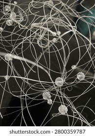 Illuminated neural network visualization on dark background — white nodes and connecting lines forming an intricate web of pathways, evoking synaptic connections or data flow in a complex system.