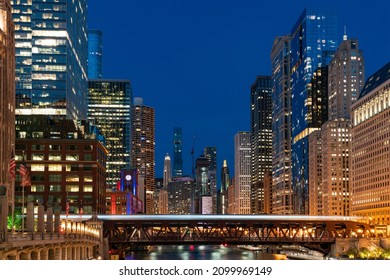 Illuminated Night Panorama Cityscape Of Chicago Downtown And River With Bridges, Chicago, Illinois, USA. A Vibrant Business Neighborhood