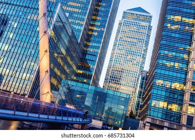 Illuminated Office Building And South Quay Footbridge In Canary Wharf, London