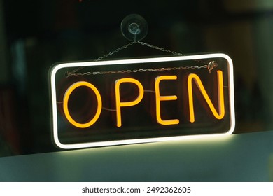 Illuminated OPEN Sign hangin in a window from a restaurant - Powered by Shutterstock