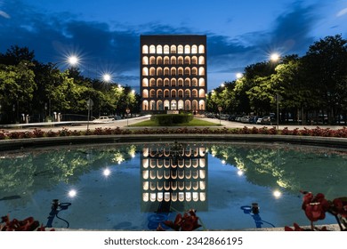 The illuminated Palazzo della Civilta Italiana and its reflection in the pond in Rome, Italy