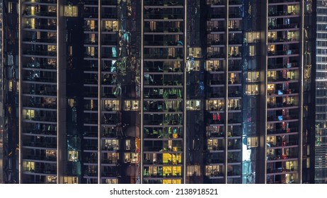 Illuminated Panoramic Windows In Apartments Of A High Class Building At Night Timelapse. Glowing Lights In Skyscraper With Balconies