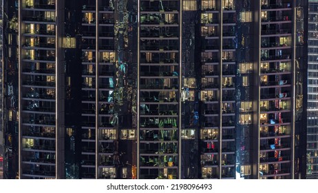 Illuminated Panoramic Windows In Apartments Of A High Class Building At Night Timelapse. Glowing Lights In Skyscraper With Balconies