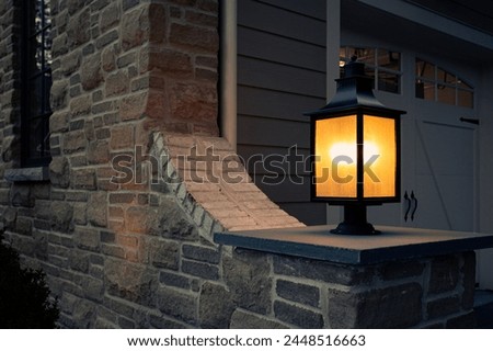 Illuminated Post Lantern Casting a Warm Glow on A Stone House Wall