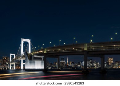 Illuminated Rainbow Bridge and night view of central Tokyo - Powered by Shutterstock