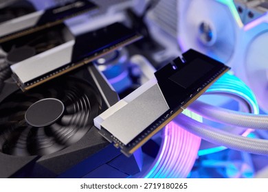 Illuminated ram module with braided cables and cooling fan, sleek metallic heatsink reflecting neon blue and purple lighting, staged for overclock bench testing