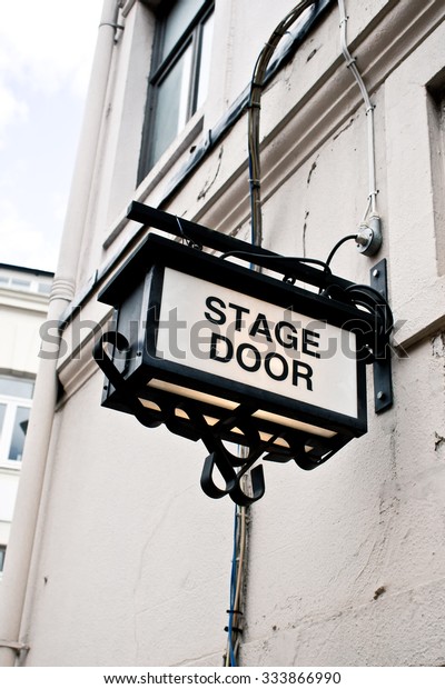 An\
illuminated sign for a stage door at a London\
theatre