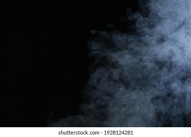 Illuminated smoke on black background in darkness