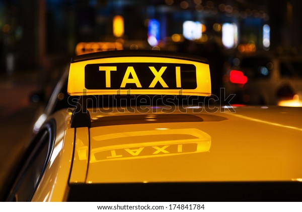 illuminated taxi sign\
on a taxi roof at\
night